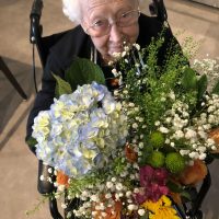 San Jose Senior woman holding a bouquet of flowersf