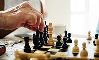 Senior Hand playing chess as part of senior living experience